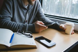 Legyen hasznos az utazással töltött idő! 2 man travels by train sitting by window uses tablet